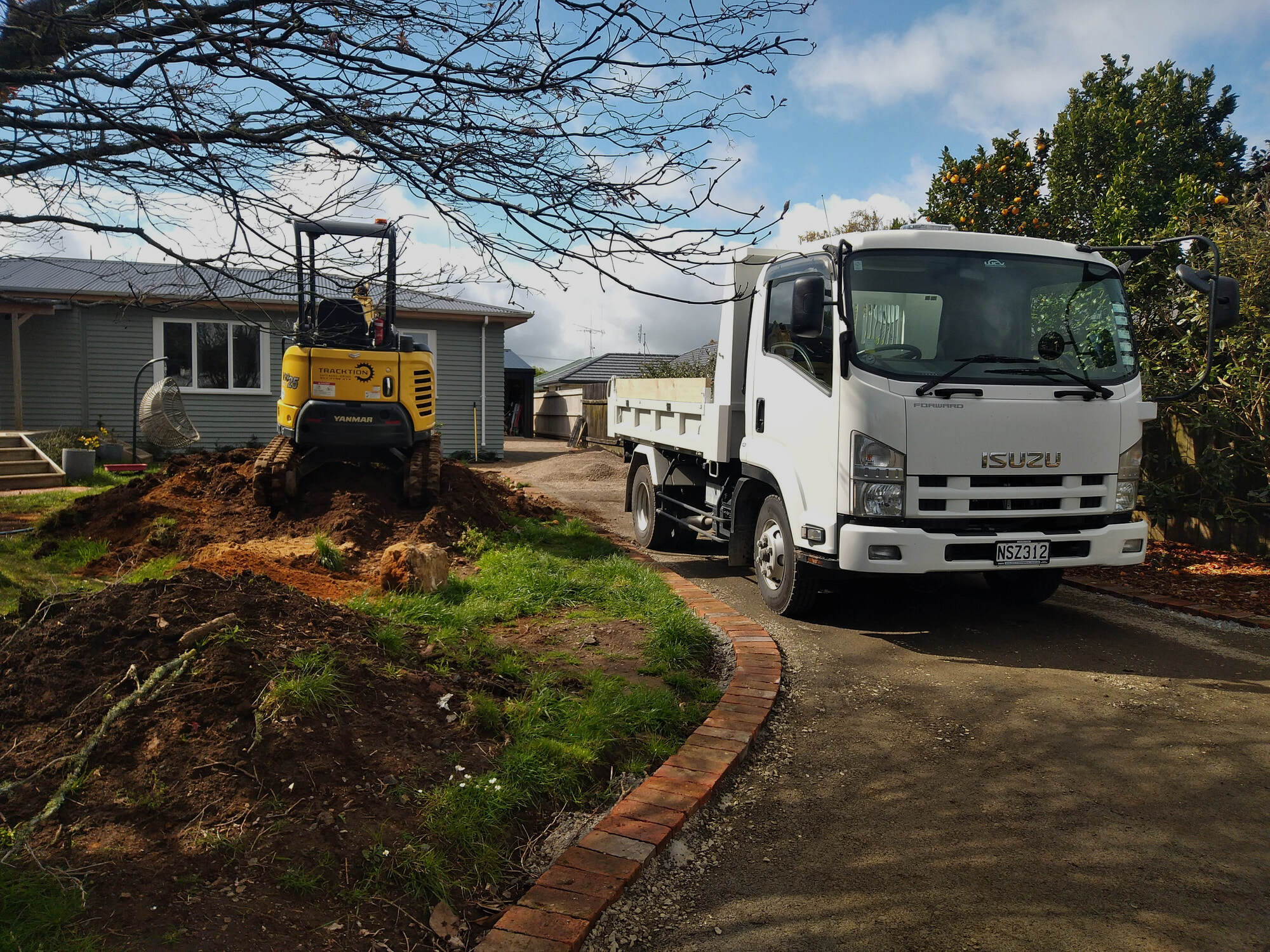 Tracktion Earthworks mini excavator and tipper truck on a residential site